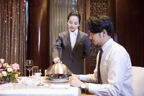 酒店服務(wù)員給顧客打開(kāi)餐蓋